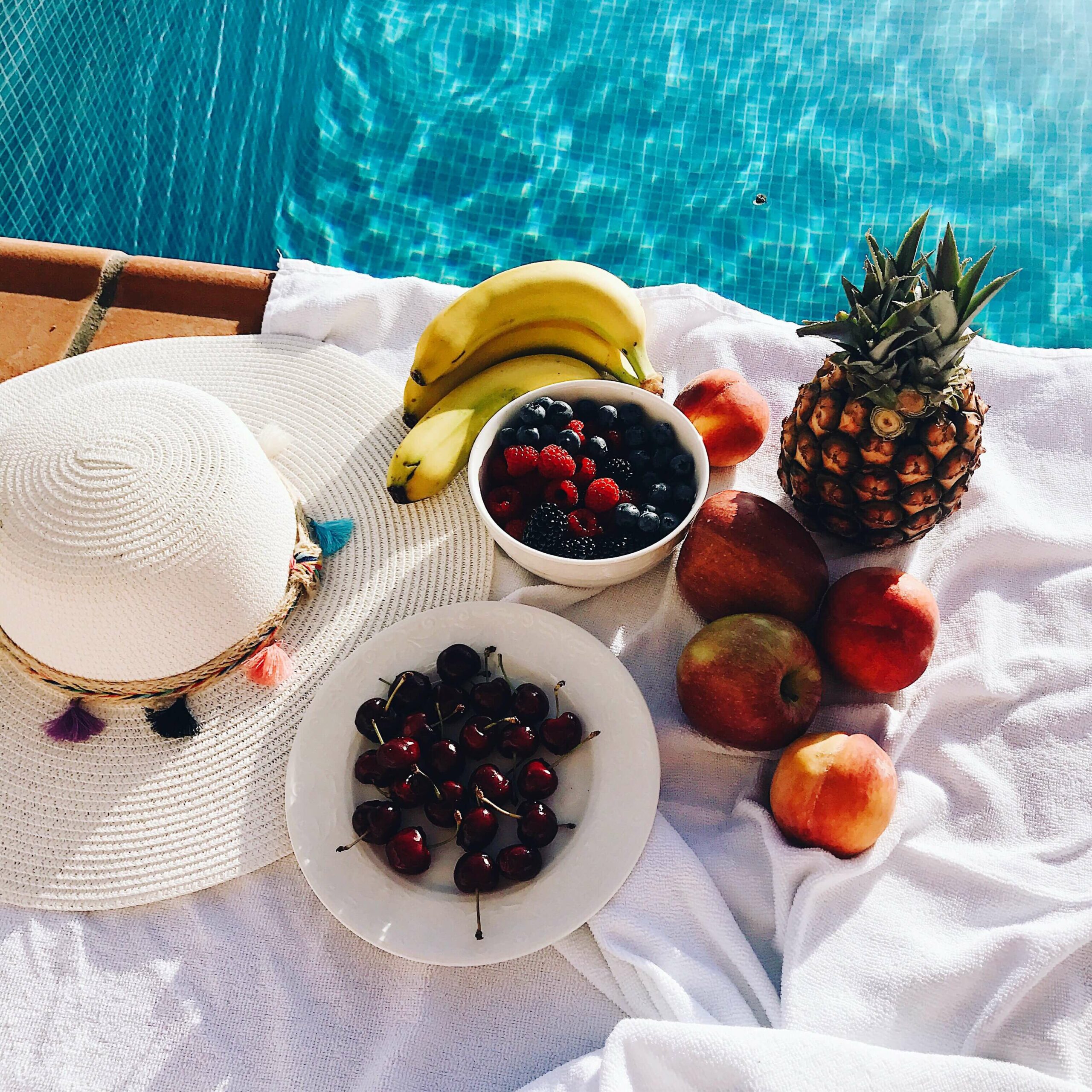high-angle-view-fruits-table-swimming-pool(1)